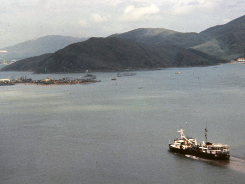 distant aerial view of a ship in the foreground and hilly shoreline in background distant aerial view of a ship in the foreground and hilly shoreline in background